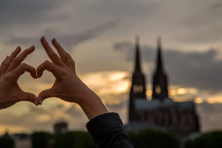 Kölner Dom im Hintergrund, vorne zwei Hände die ein Herz bilden| Copyright: AdobeStock